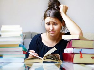 Frau, die verzweifelt in einem Buch liest.